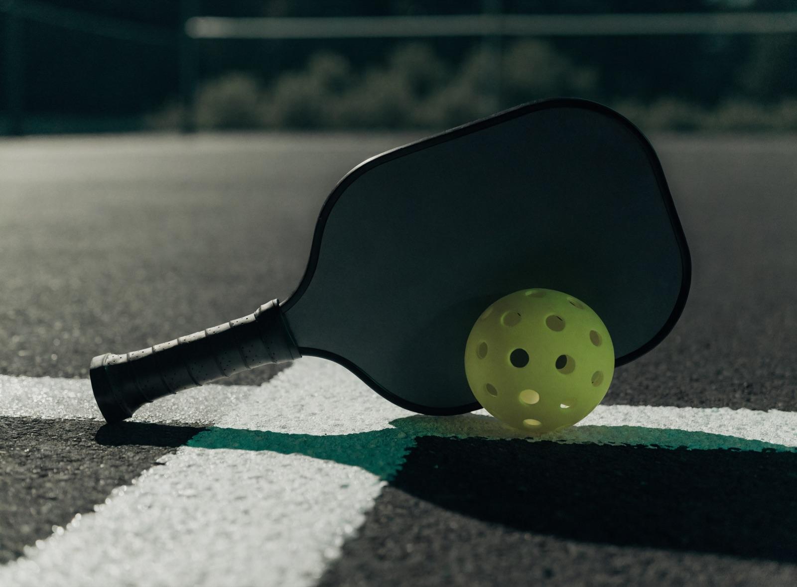 A beginner-friendly paddle and ball on a freshly painted recreational court. Representative budget-and-beginner-category image.
